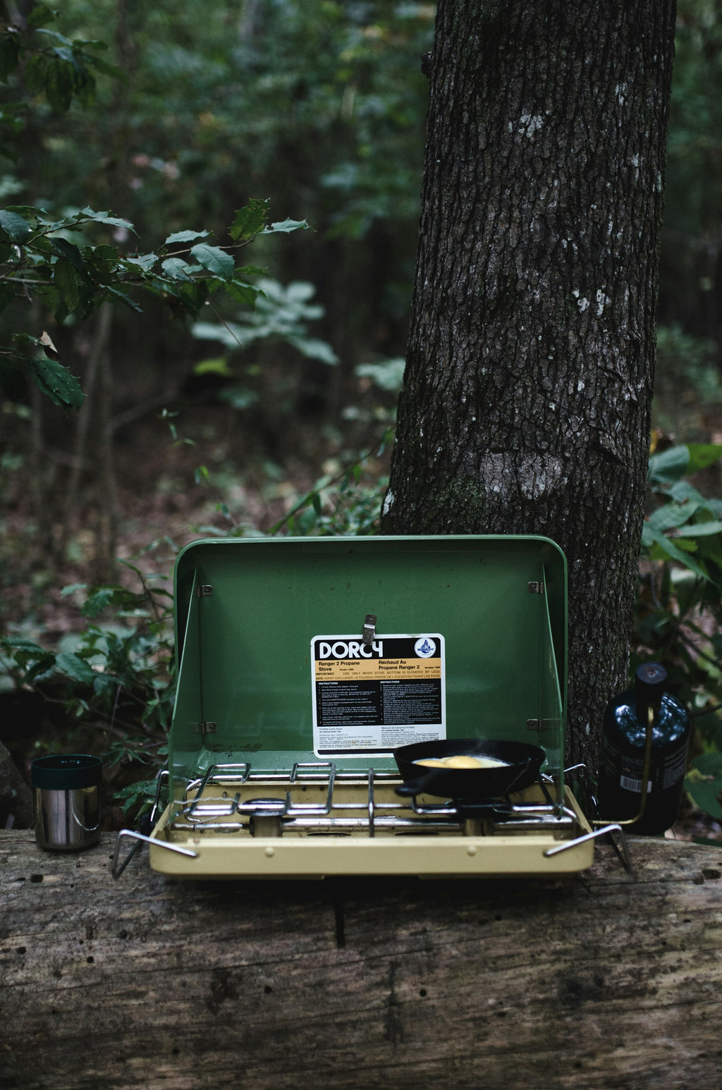 Camping stove cooking eggs on pan during trail meal prep