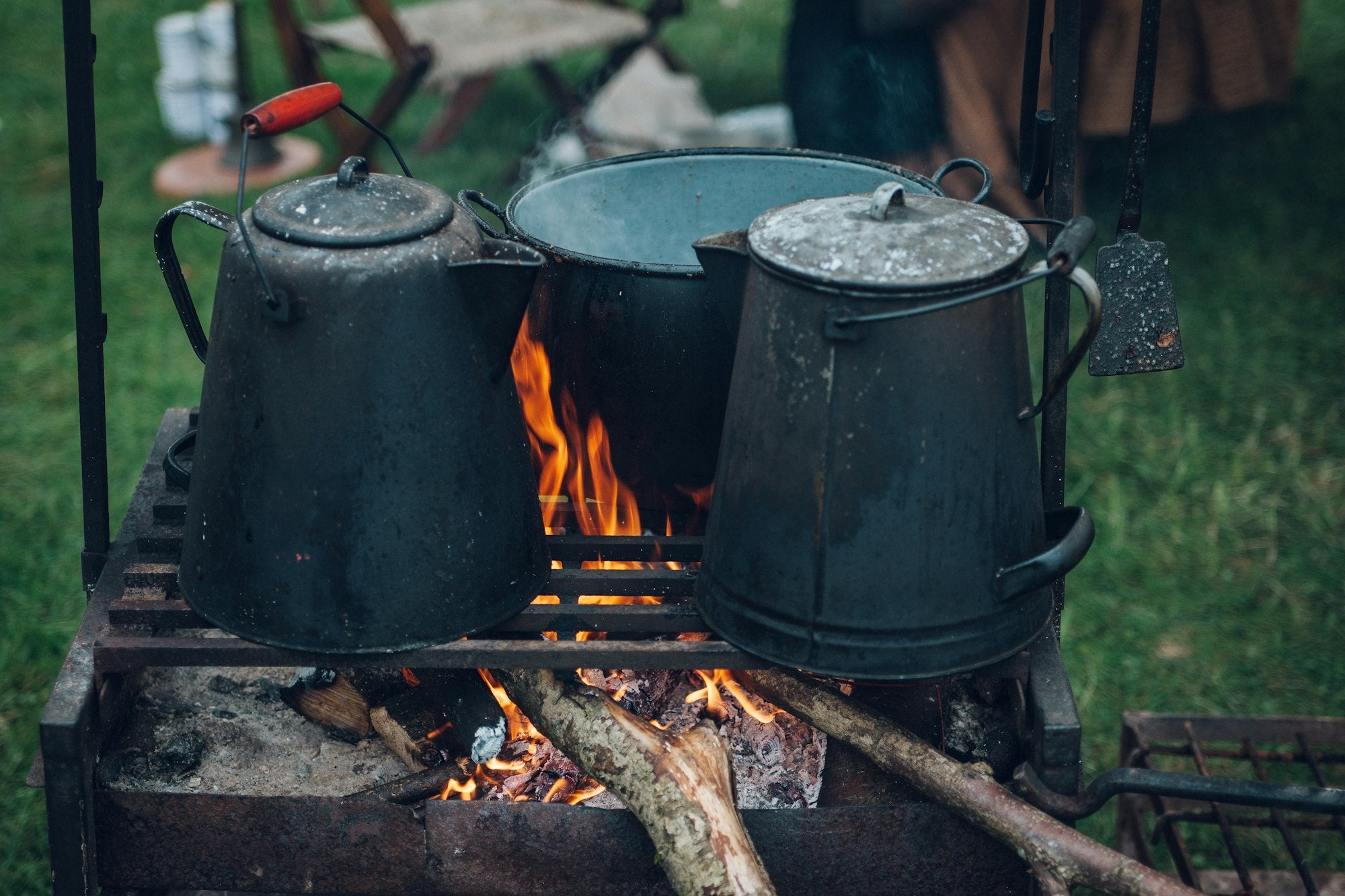 Kettles boiling water on campfire for hot meals