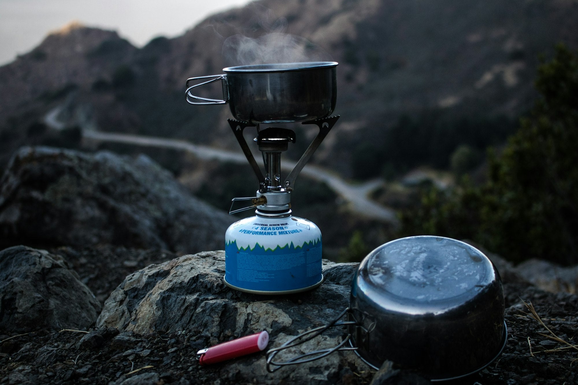 Trail 123 stove with cooking pan over scenic camp view